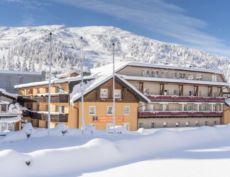 Das verschneite Familienhotel Hinteregger in Katschberg vor einer malerischen Bergkulisse