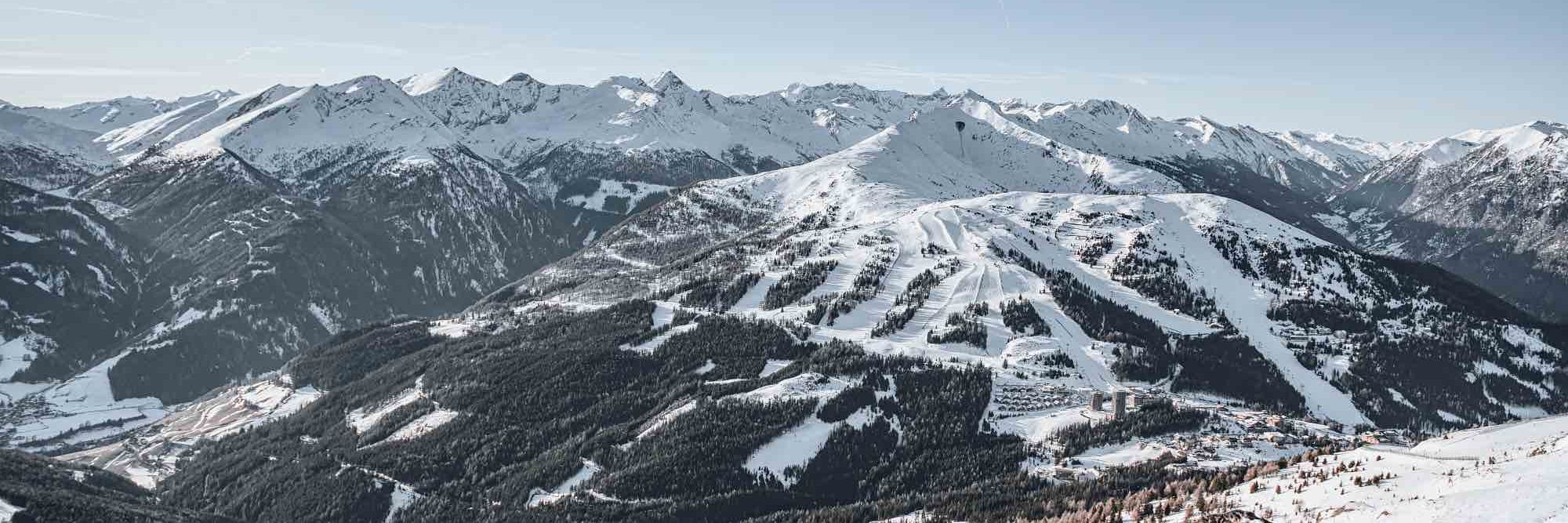 Ein weitläufiges Panorama von schneebedeckten Bergen und Tälern, aufgenommen von einem hohen Aussichtspunkt