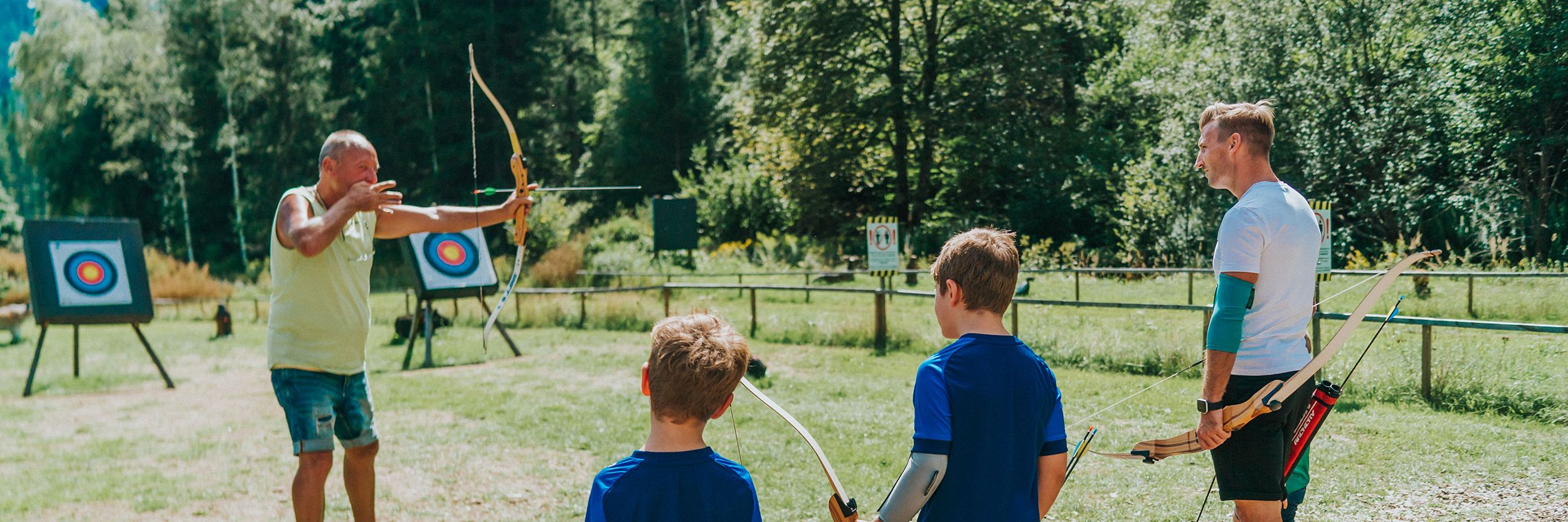 Kinder am Bogenparcour mit Trainer